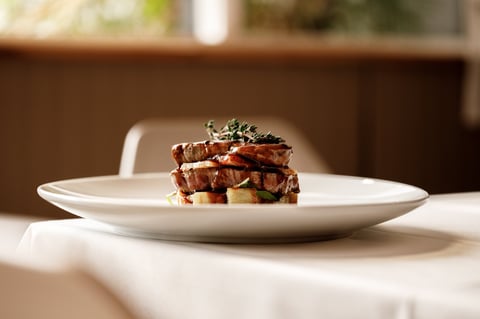 Gourmet sandwich with bacon and greens in an upscale restaurant setting