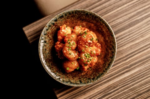 Shrimp in red sauce with herbs in a rustic ceramic bowl
